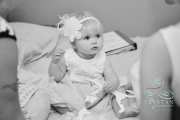 The cutest little flower girl watches the bride get ready before a wedding.
