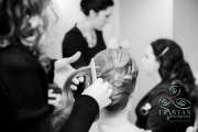 A bride getting her hair pinned up into an up-doo before a wedding.