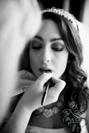 A beautiful bride getting the final touches on her lip makeup before the wedding.
