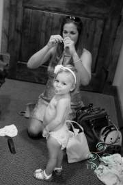 A tiny baby flower girl sucking on her pacifier as she waits to be dressed before the wedding.