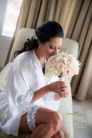 A bride smelling her bouquet before the wedding.