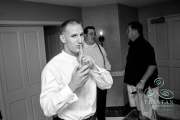 A photograph of a groom sneaking one last cocktail and shushing the photographer because he wasn't supposed to have any cocktails before the wedding.