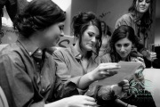A bride reading a love letter from the groom surrounded by her bridesmaids before the wedding.