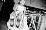 A close-up of a bride's boots that have "Gettin' Hitched" written on the soles of the boot.