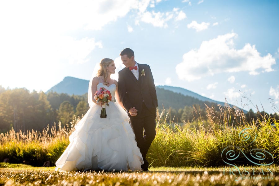Wedding Photography at Deer Creek Valley Ranch in Colorado - A bride and groom walking together in a field