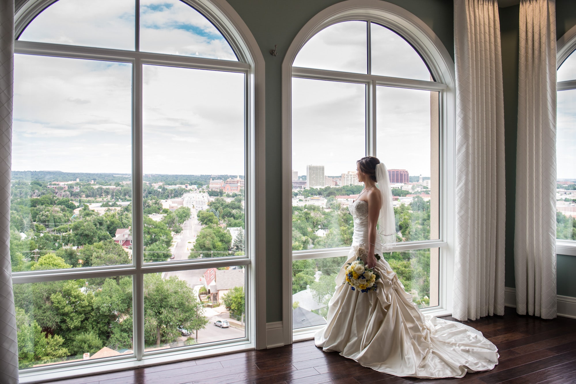 A bride looking out the windows of The Pinery at The Hill