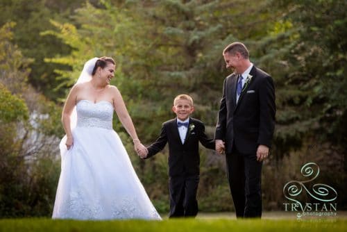 A bride and groom walking with their son at their wedding at The Briarhurst Manor.