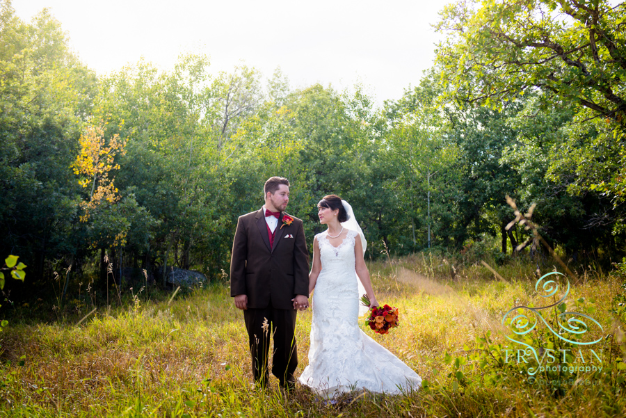 A bride and groom walking through a mountain meadow at Brush Canyon Ranch