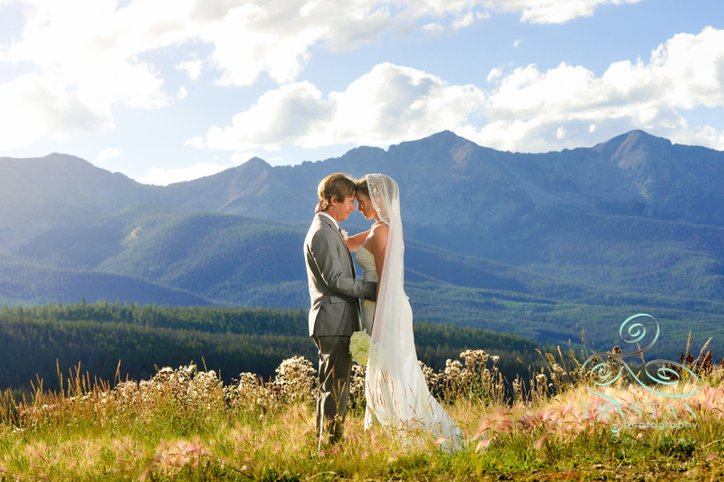 A photography of a couple facing each other and holding each other on top of a mountain at their wedding at Placer Gulch in Breckenridge, Colorado.