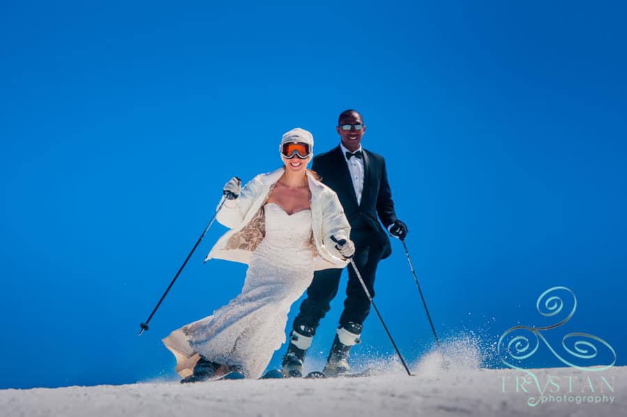 A photograph of a bride and groom skiing in their wedding gown and tuxedo at Keystone Mountain in Colorado.